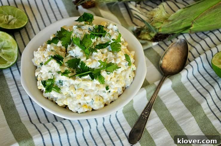 A rustic bowl of Grilled Mexican corn recipe, beautifully presented on a vibrant green napkin, garnished with fresh herbs and a lime wedge.