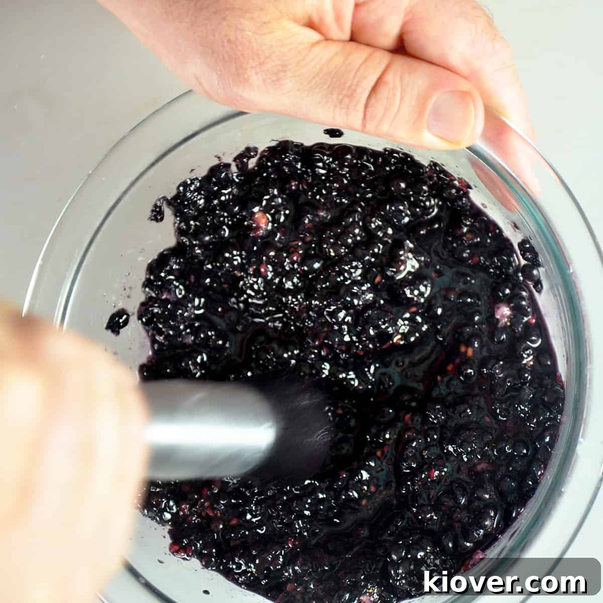 Using a tool to squish blackberries.