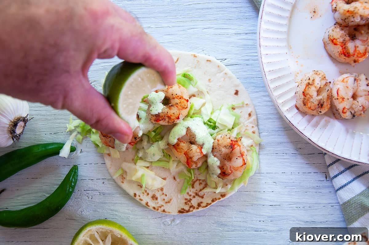 Pouring the Chili Lime Shrimp Taco Sauce on top of the Grilled Shrimp Tacos