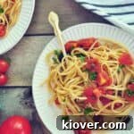A plate of Puttanesca Sauce with Linguine on a white plate with a gold spoon.