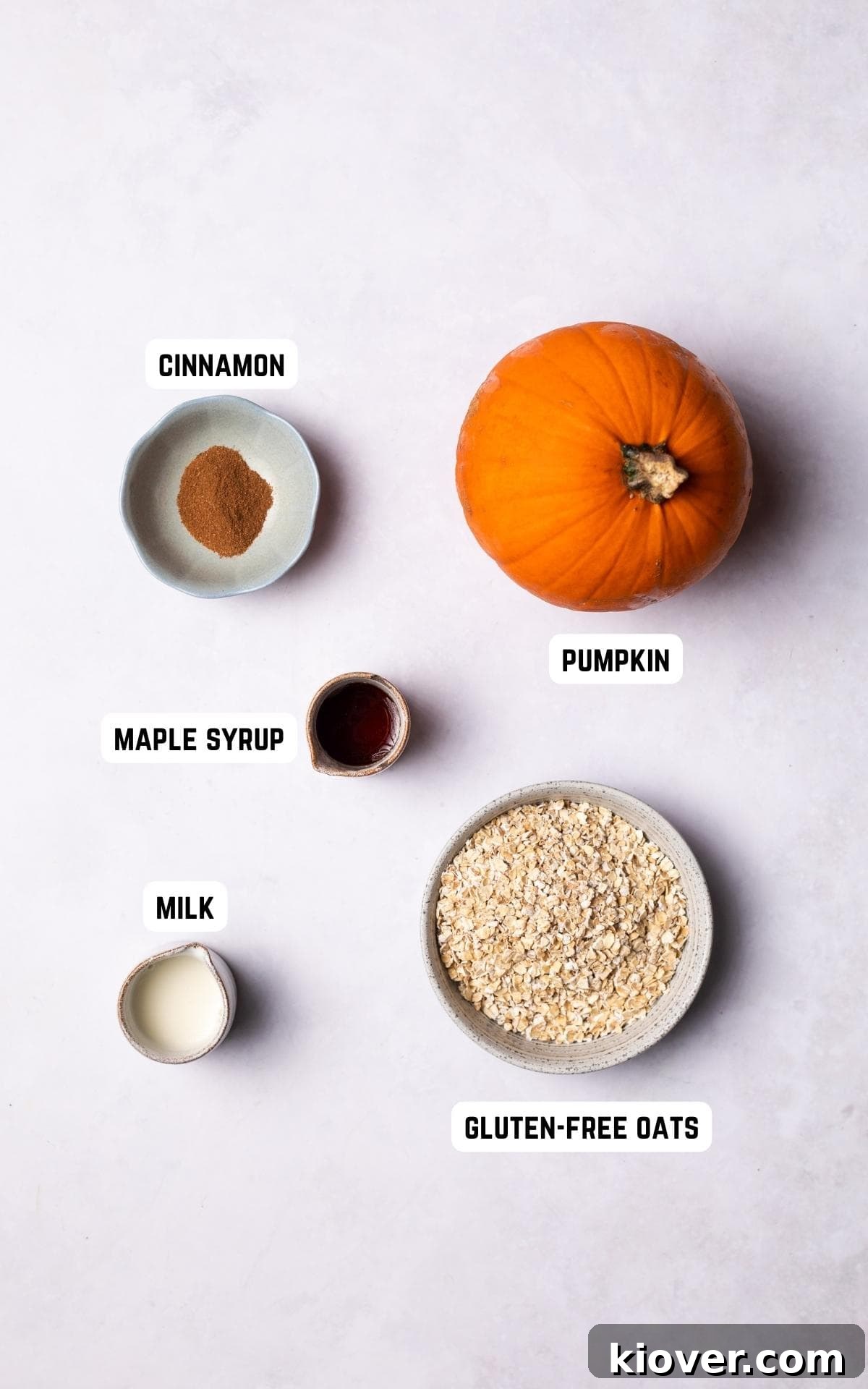 Golden Pumpkin Oat Bliss 3 An array of fresh ingredients laid out for making Pumpkin Oatmeal, including pumpkin chunks, maple syrup, cinnamon, oats, and milk.