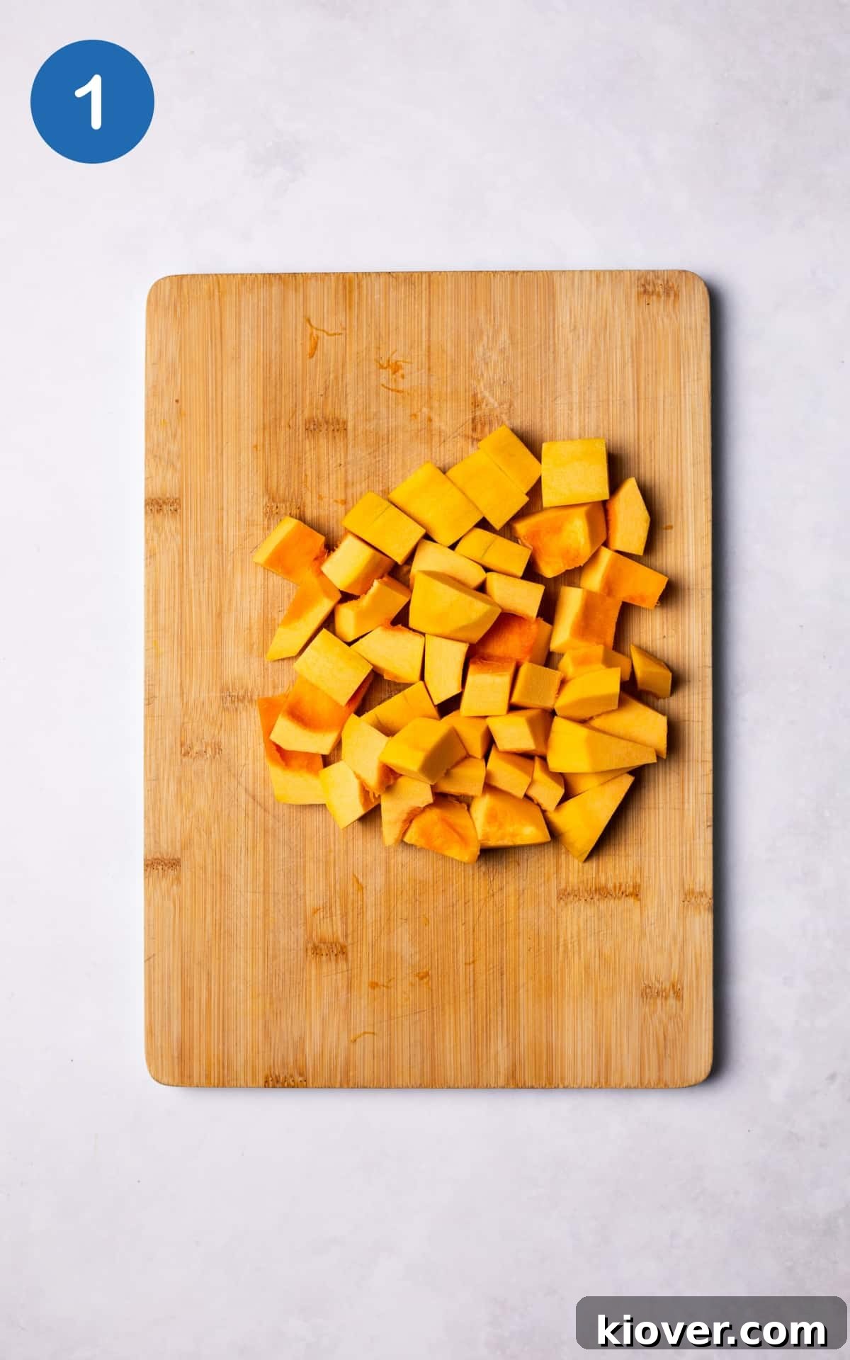 Golden Pumpkin Oat Bliss 4 Fresh pumpkin chunks neatly arranged on a wooden cutting board, ready for cooking.