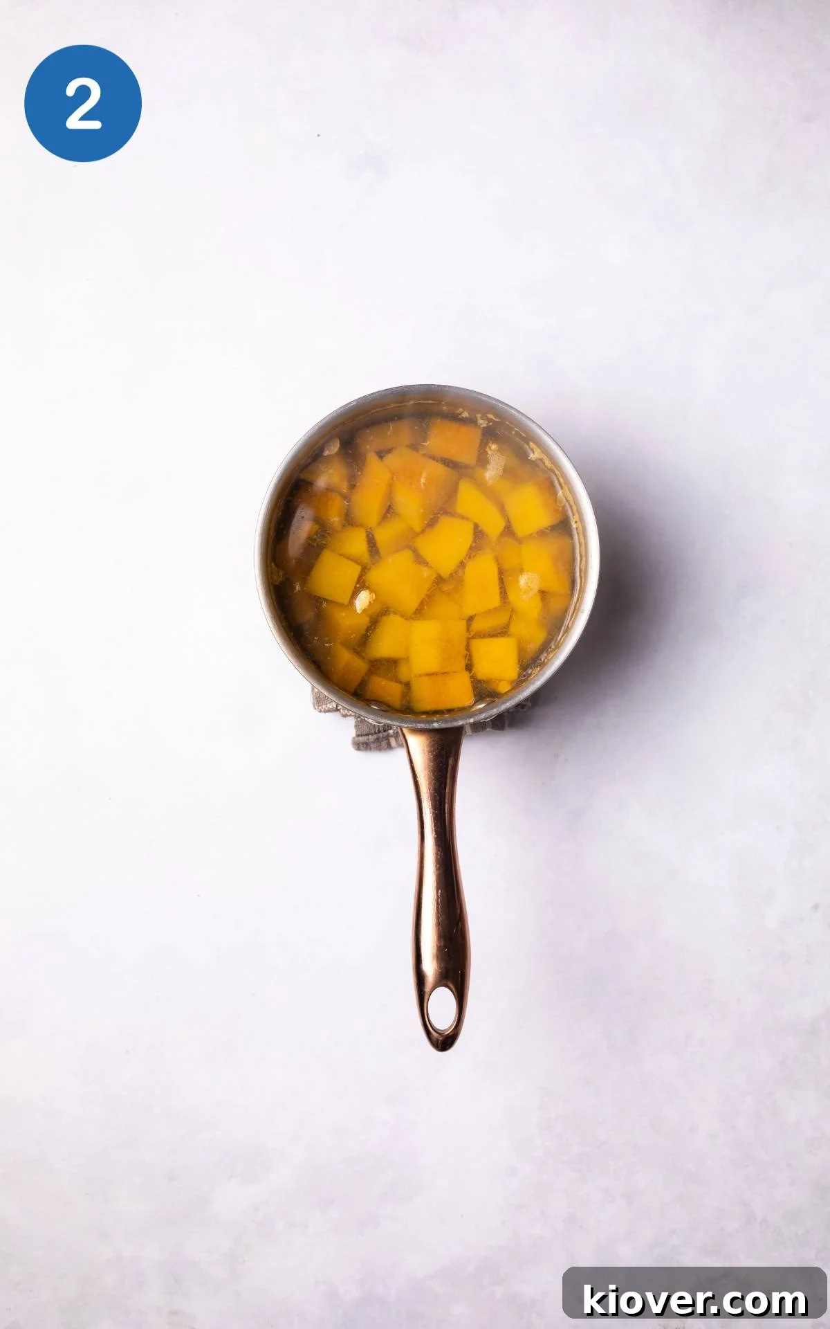 Golden Pumpkin Oat Bliss 5 Pumpkin chunks immersed in water, simmering gently in a cooking pot on the stove.
