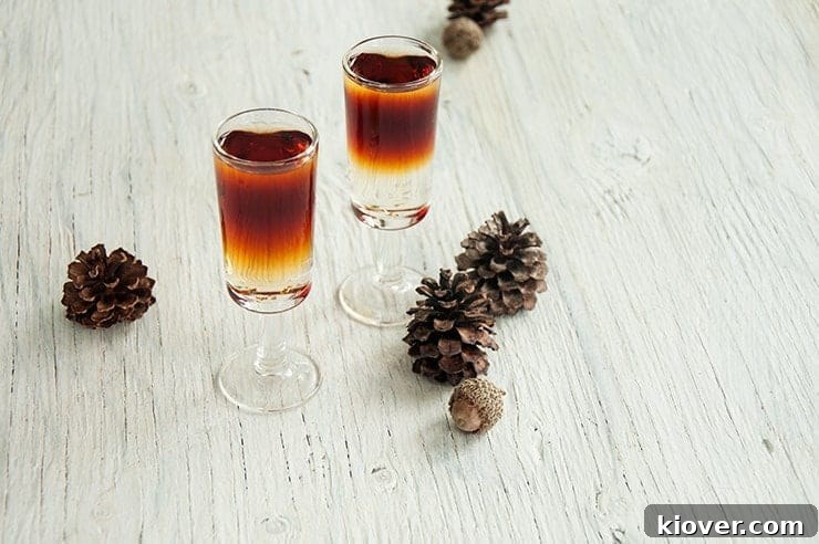 Two Total Yodel Shots on a table with pine cones in the background.