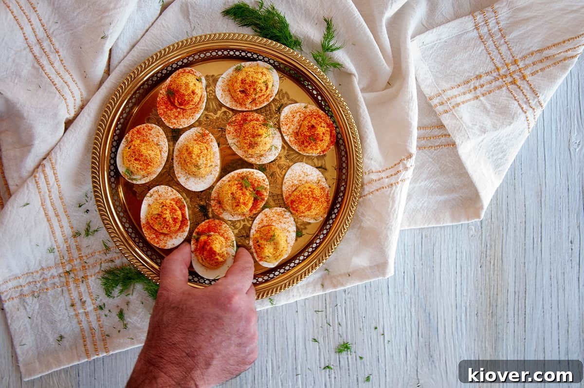 A hand reaching to grab a spicy deviled eggs.