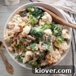 Extra Baconey Amish Broccoli Salad Recipe in a white bowl with a wooden spoon!