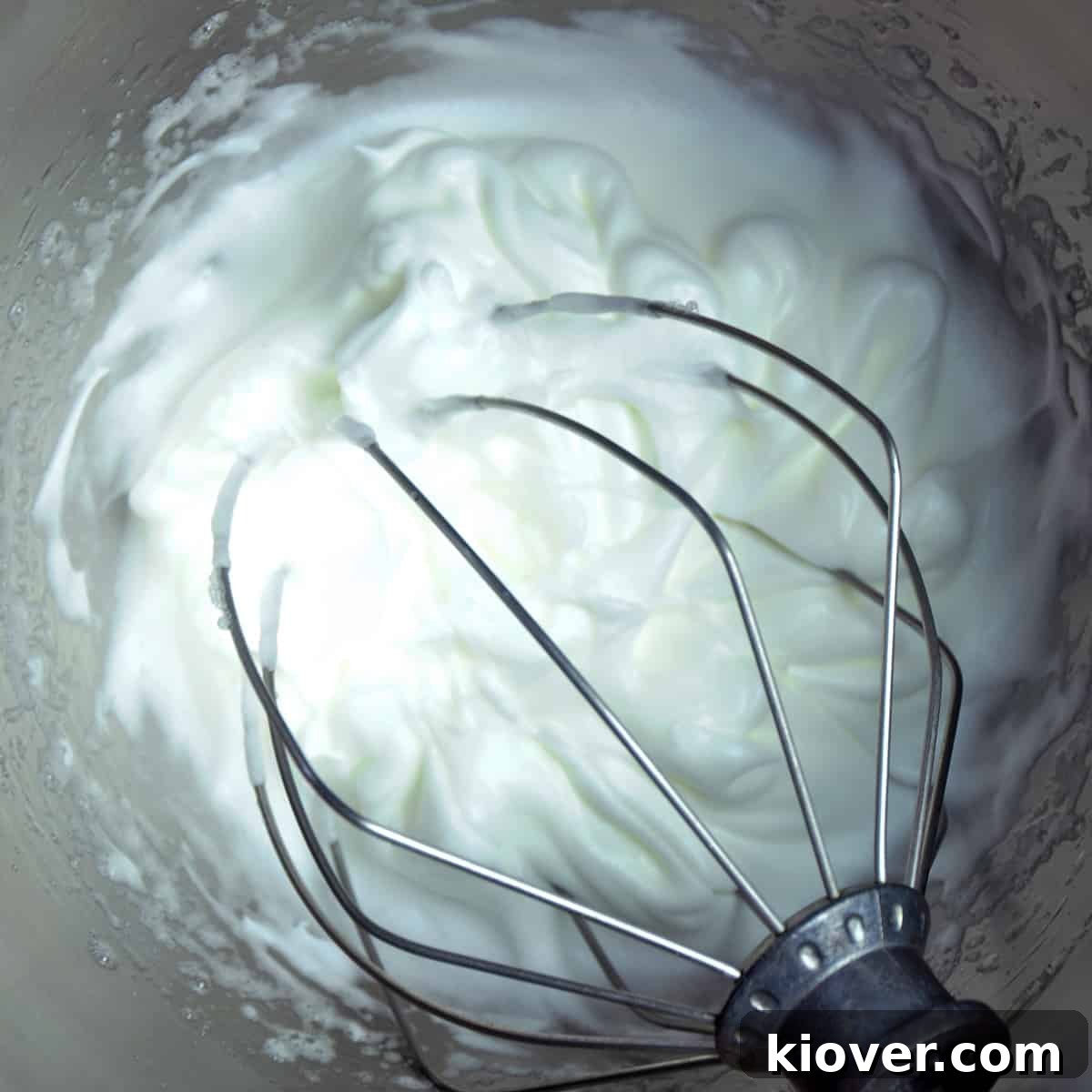 Whipped Egg Whites Whipped egg whites in KitchenAid mixing bowl, forming firm peaks.