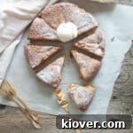 Norwegian Rhubarb Cake cut into eight pieces on white parchment paper.