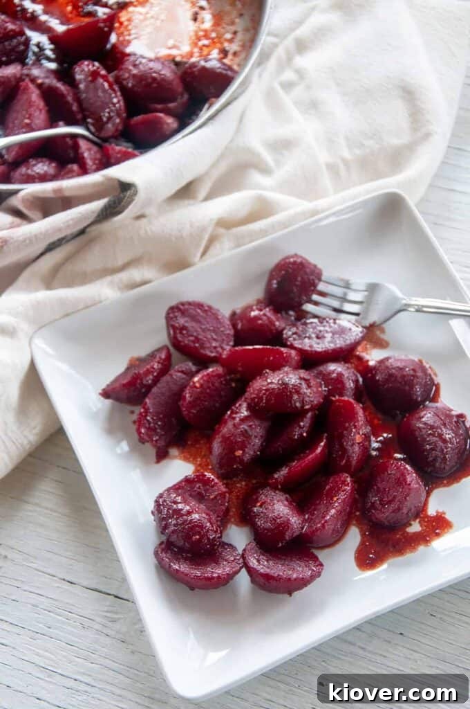 Fried Beets on a square white plate with a frying pan in the background, ready to be served.