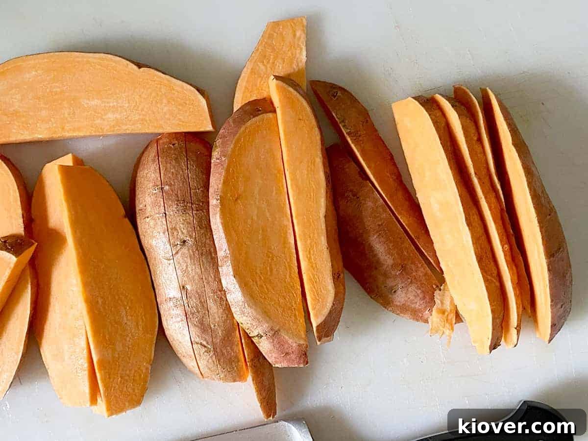 Smoky Bacon-Wrapped Grilled Sweet Potato Sticks 3 A close-up process picture showing sweet potato fries meticulously cut into consistent 1/2-inch wedges, demonstrating the ideal size and shape for optimal grilling and bacon wrapping.