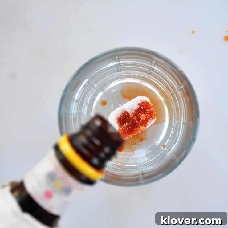 Overhead Bitters Application Pouring bitters over a sugar cube in a glass, an essential first step for any Old Fashioned.