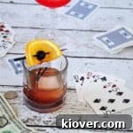 A picture of a Mad Men Old Fashioned cocktail on a park table with cards in the background, signaling a delightful drink.