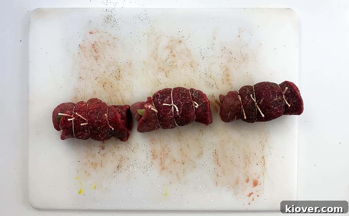 Three rouladen all rolled up and tied with butcher's twine.