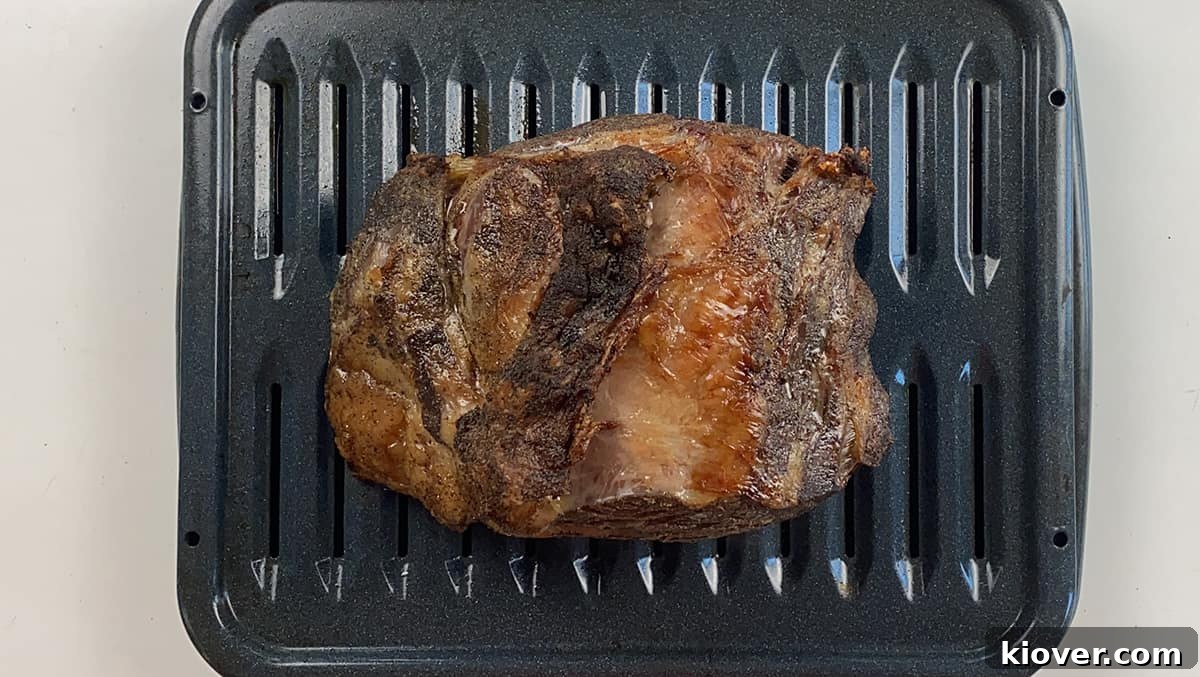 Resting Rib A beautifully seared prime rib roast, fresh from the oven, resting majestically in a roasting dish, showcasing its perfect golden-brown crust.