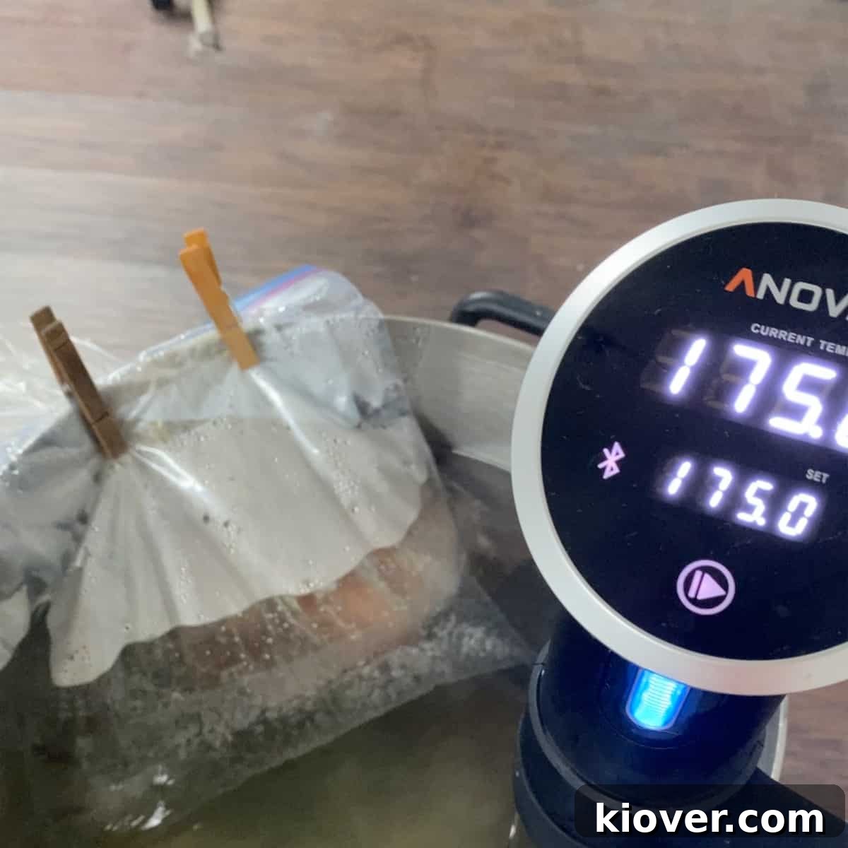 Sous Vide cooker set to 175 in a large pot with a corned beef roast and a bag of water on top weighing it down.