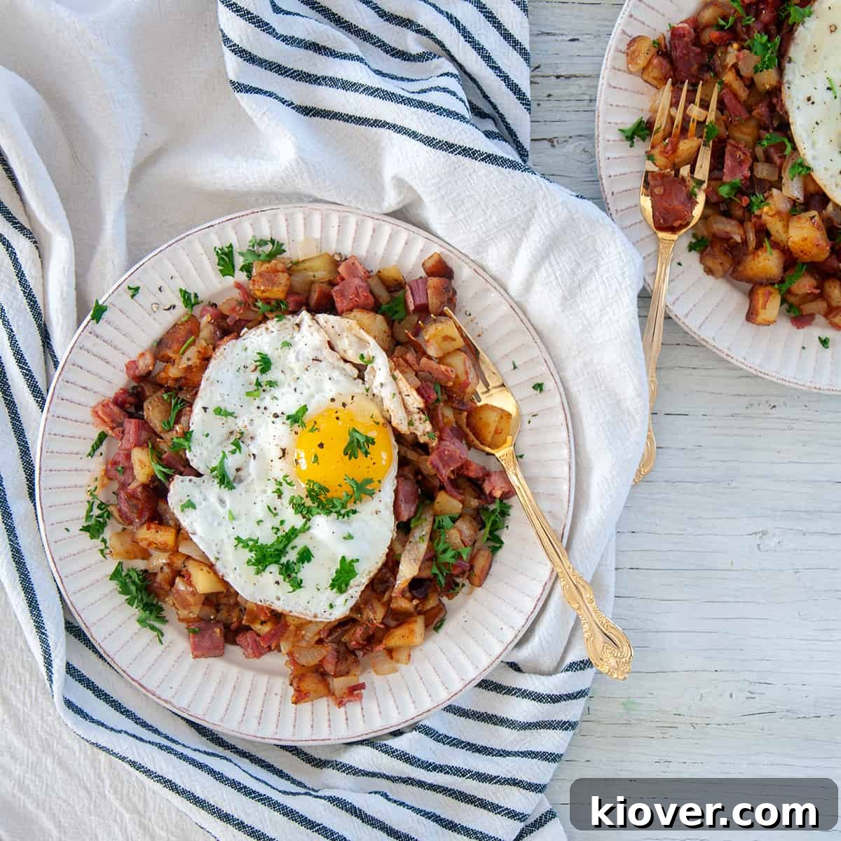 Crispy Homemade Corned Beef Hash 2 A vibrant plate of crispy Corned Beef Hash topped with a perfectly cooked sunny-side-up egg, ready to be enjoyed for breakfast.
