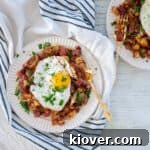 Corned Beef Hash on a white plate with a single sunny side up egg on top.