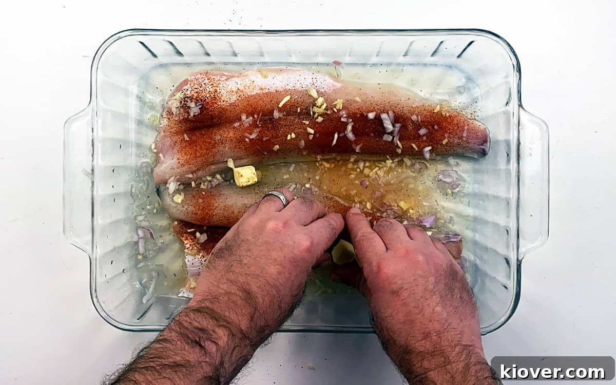 Evenly spreading cubes of butter over unbaked walleye.