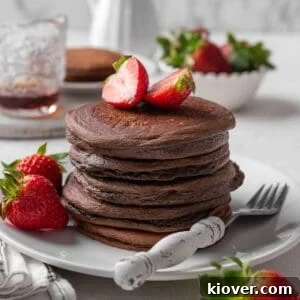 Decadent Chocolate Pancakes Recipe for Fluffy, Fudgy Stacks 13 chocolate pancakes with strawberries.