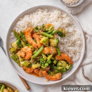 prawn stir fry served on a white plate with white rice.