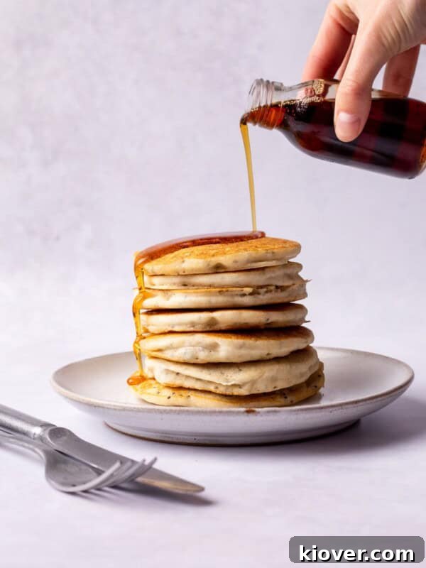 Pouring Maple syrup over gluten free pancakes.
