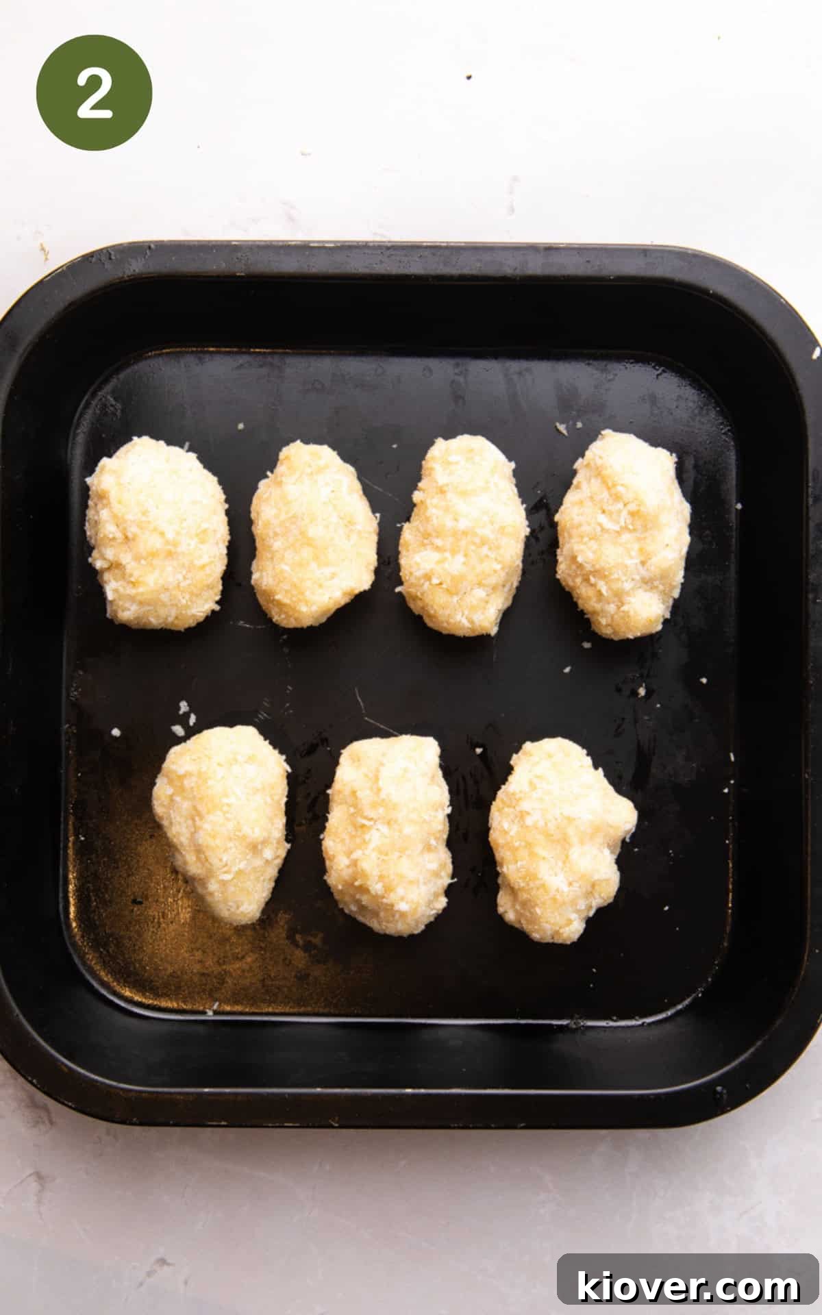 How to Make Homemade Bounty Bars: Chewy Coconut Chocolate Bars 5 coconut bar shapes on a baking tray.