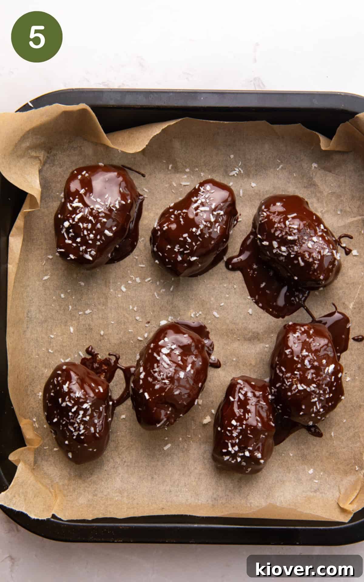 How to Make Homemade Bounty Bars: Chewy Coconut Chocolate Bars 8 bounty bars with melted chocolate on a baking tray.