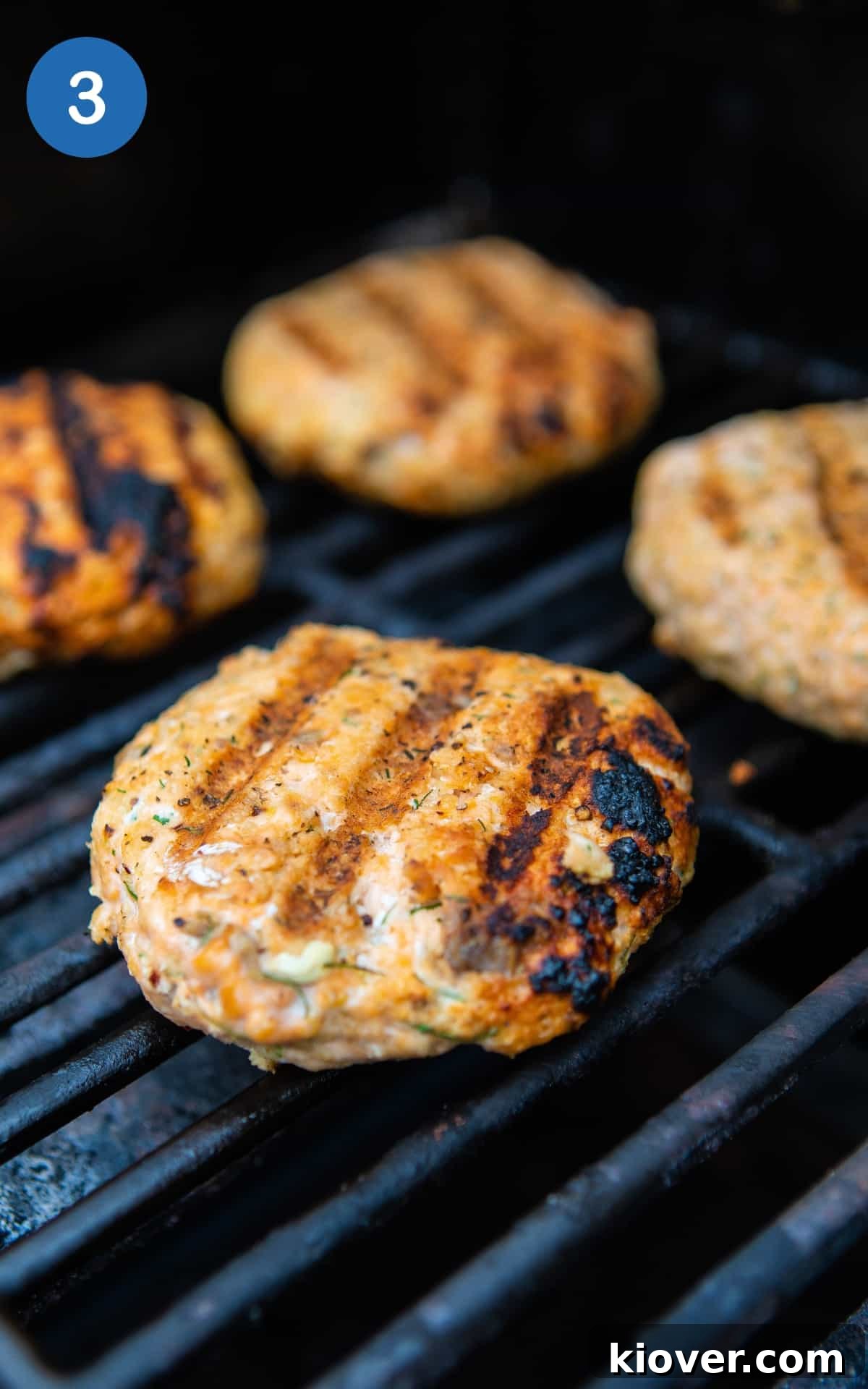 Grilled Salmon Burgers with Lemon-Dill Aioli 6 salmon burgers cooking on black bbq.