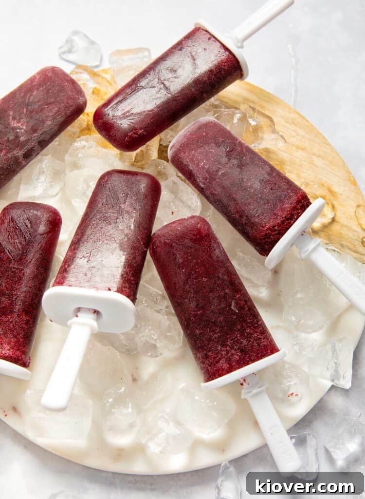 Blueberry Frozen Yogurt Popsicles: Refreshing Summer Treat 6 blueberry ice lollies served on ice.