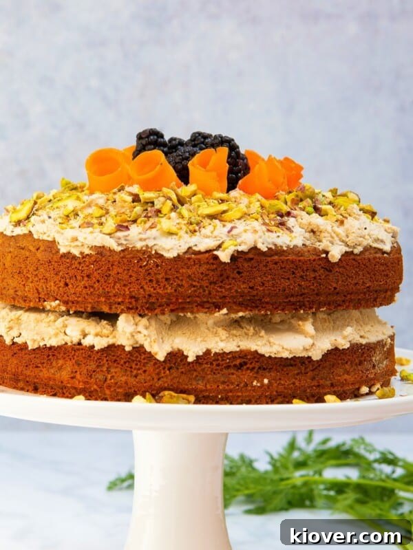 carrot cake on white cake stand with grey marbled background.