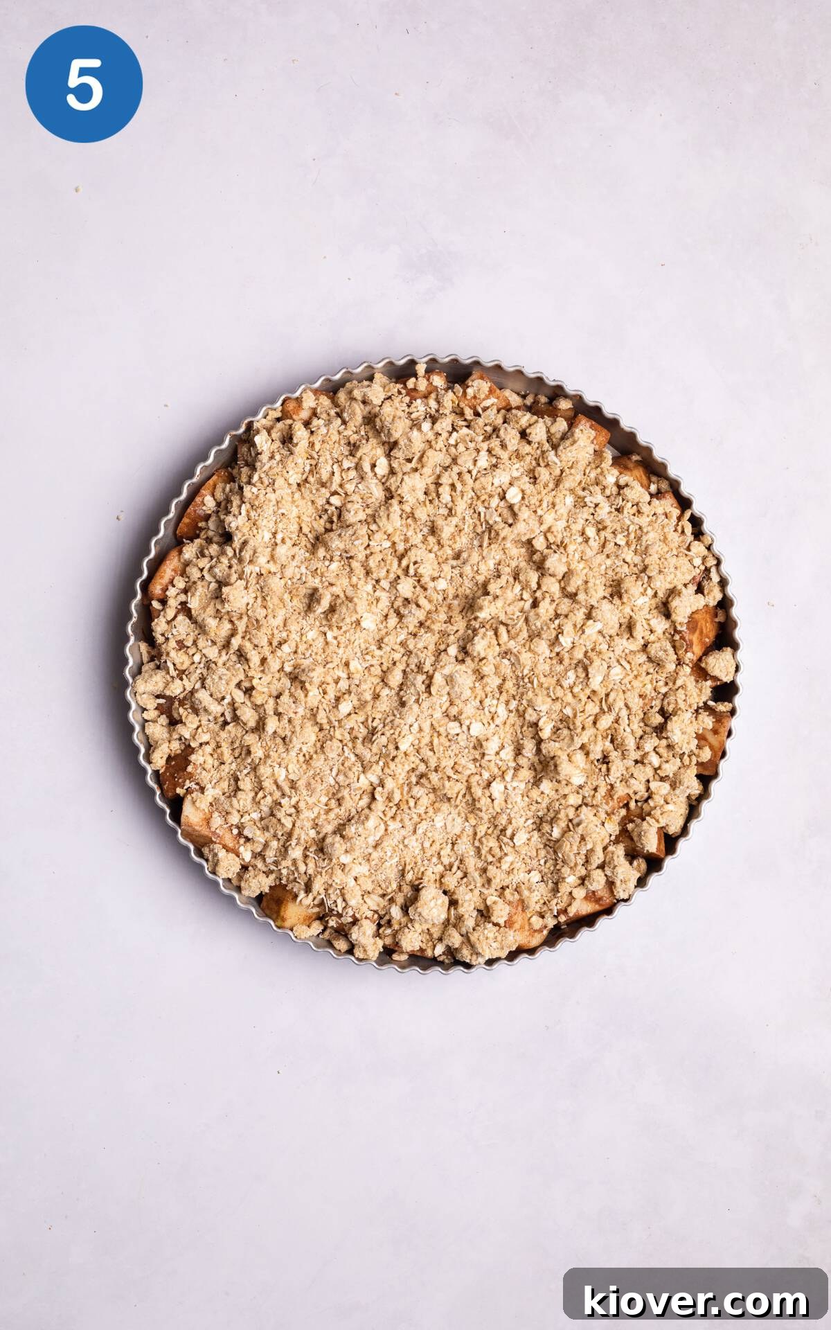 pear mix topped with oat crumble topping in a baking dish.