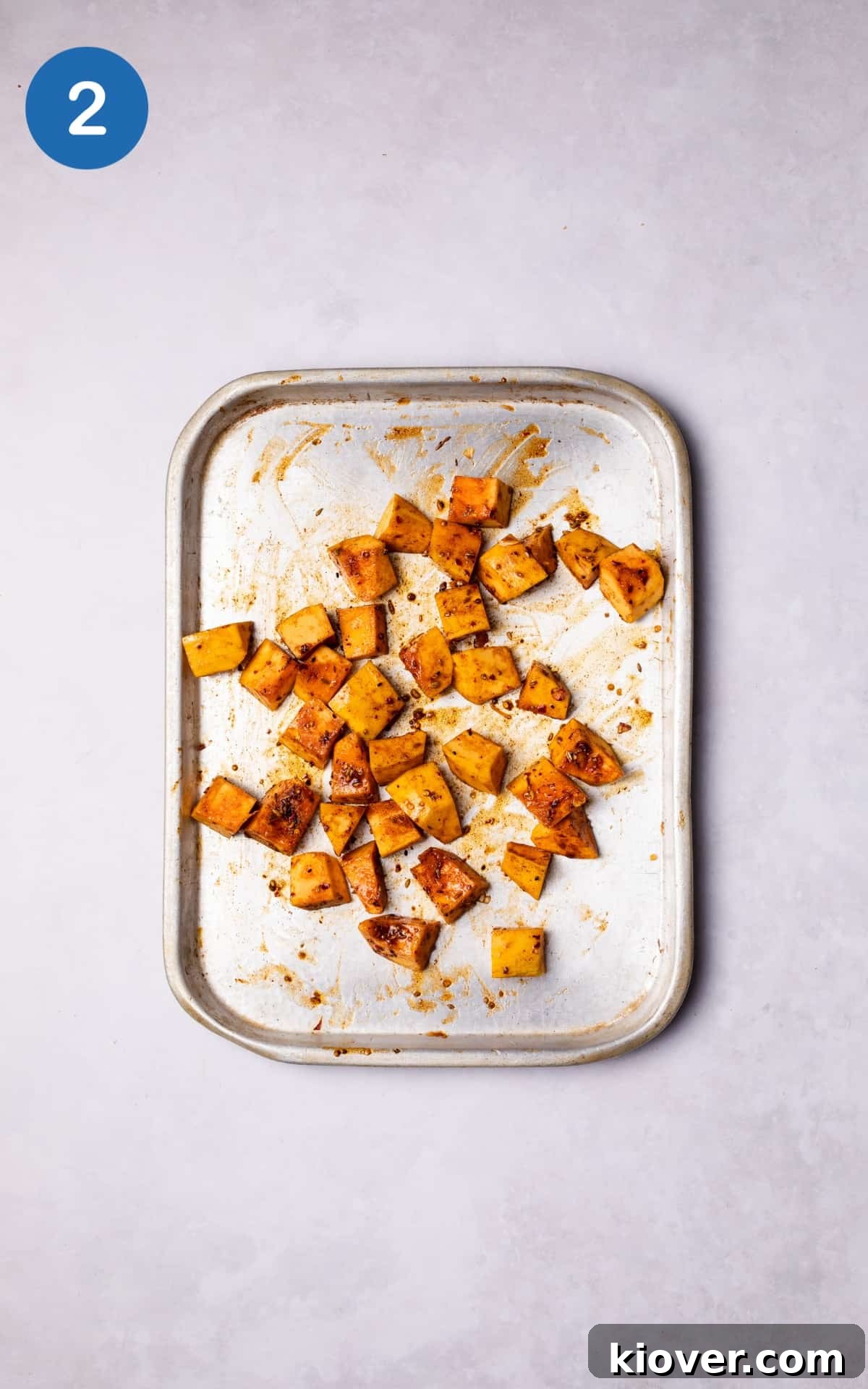 Pumpkin mixed with spices on a baking tray.