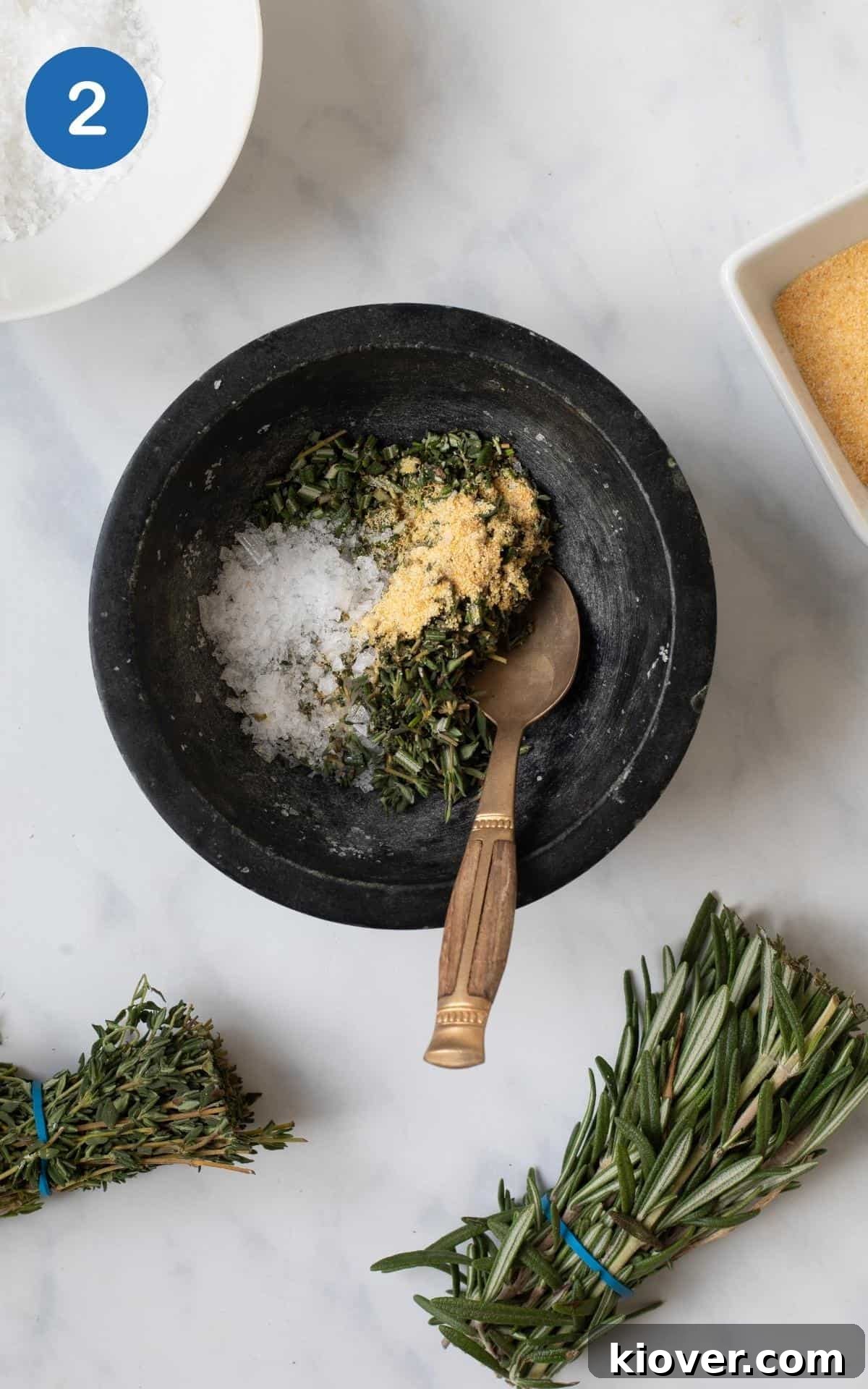 Crispy Hasselback Potatoes with Garlic and Parmesan 5 thyme, rosemary, salt, garlic granules, olive oil in a black mortar bowl.