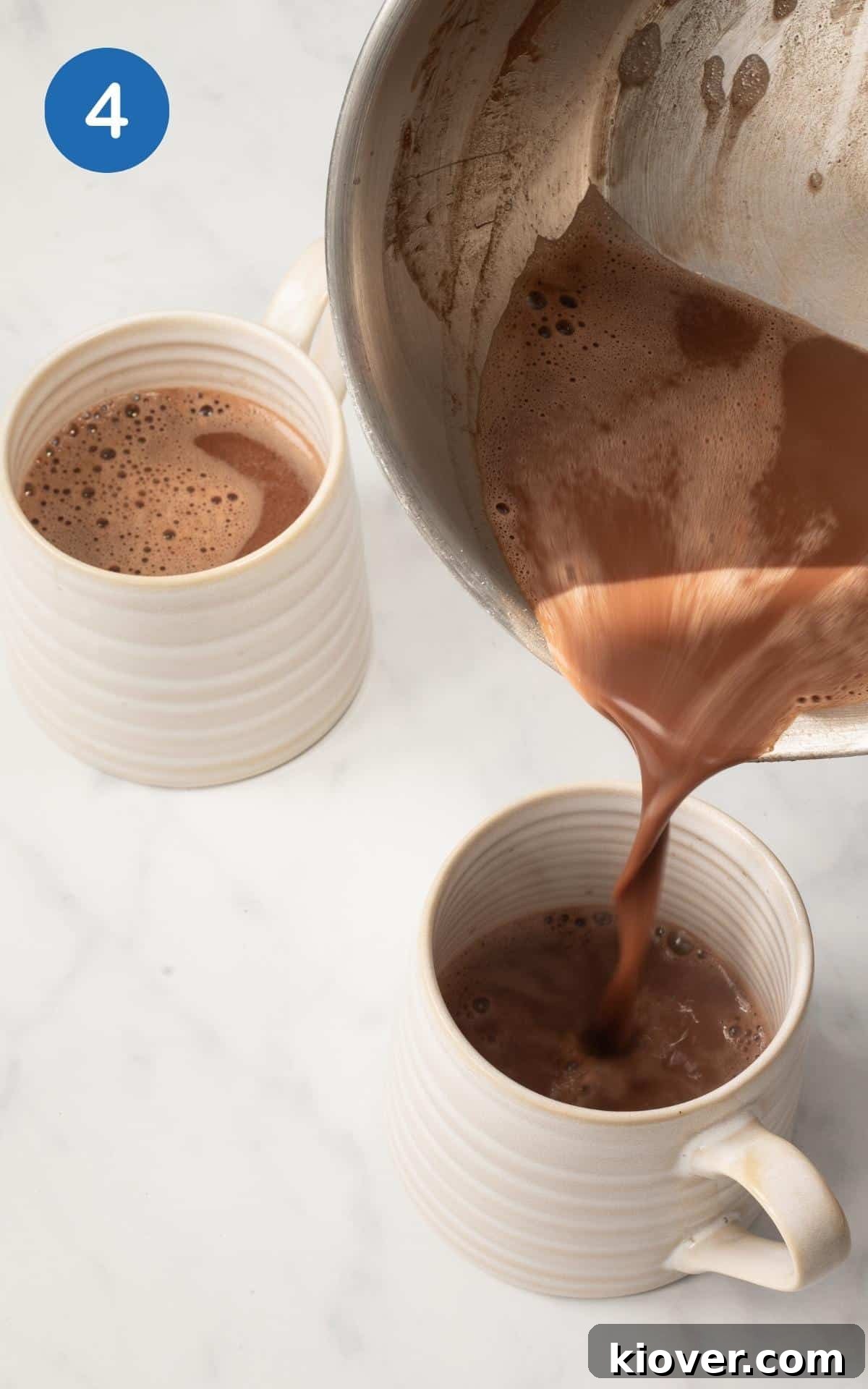 Pouring the Christmas Hot Chocolate into a white coffee cup.