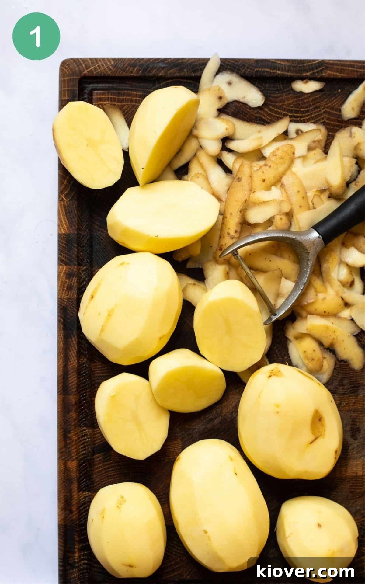 image of potatoes being peeled and chopped on a brown cutting board.