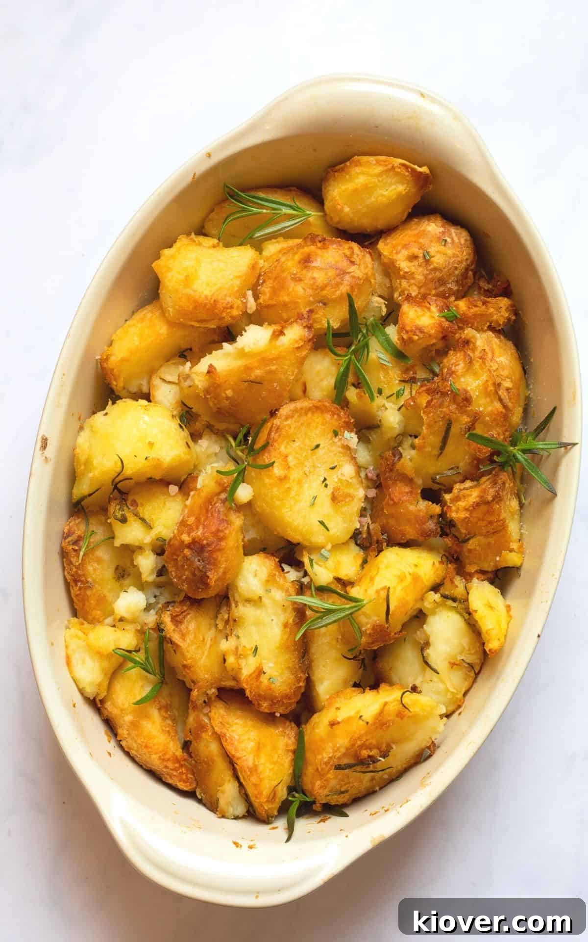 baked rosemary roast potatoes in an oval baking dish.