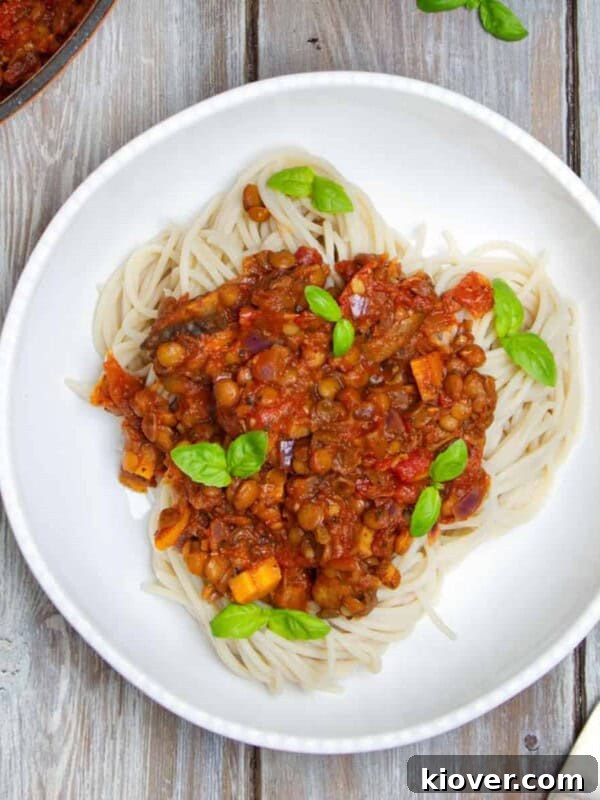 Crispy Vegan Sausage Rolls: Flaky Pastry with Savory Filling 11 Spaghetti Bolognese topped with fresh basil in a bowl. Bowl is on a wooden background.