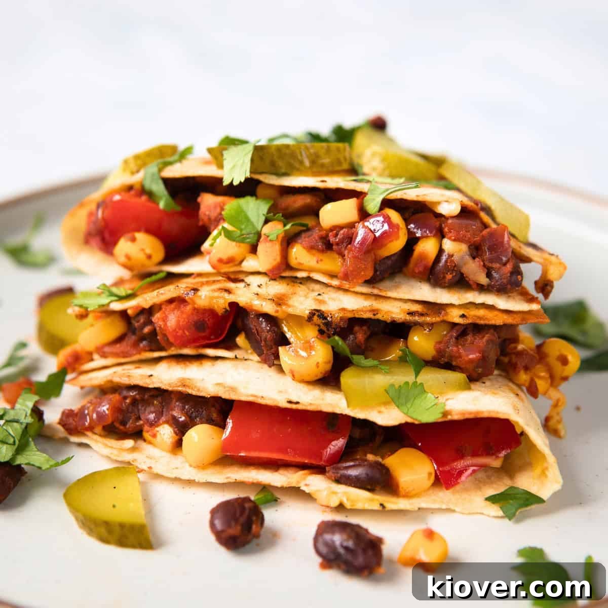 Black Bean Quesadillas with Melty Cheese and Fresh Salsa 2 filled black bean quesadillas on a white plate.