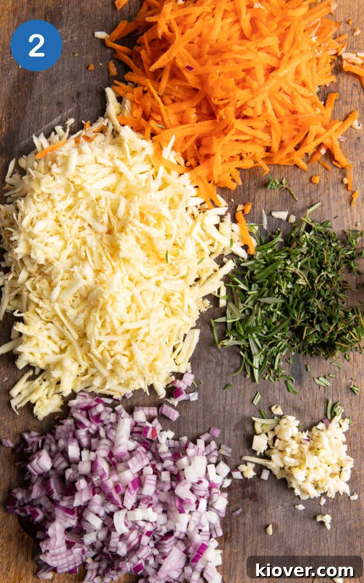 Vegetables and herbs finely chopped on a wooden chopping board.