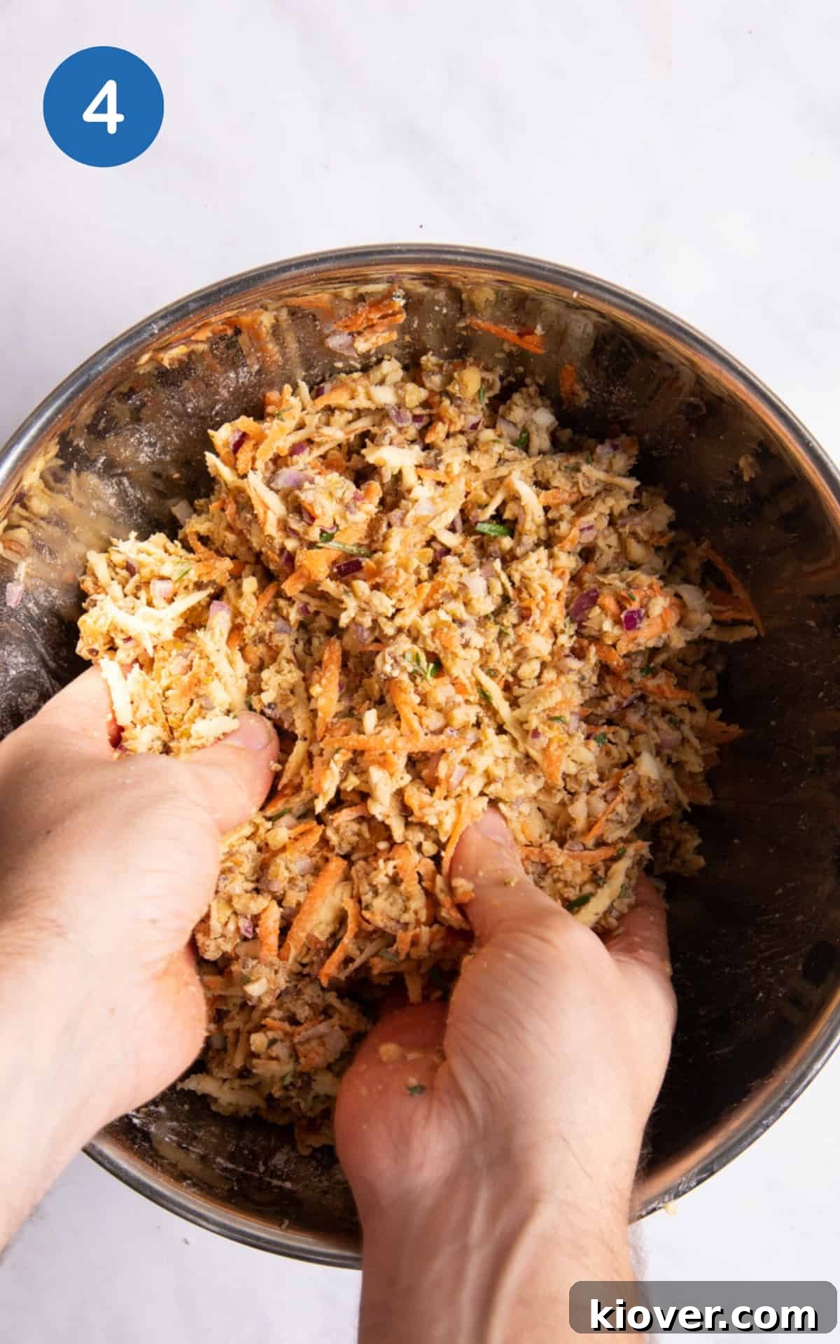 Ingredients being mixed together by hand in a large mixing bowl.
