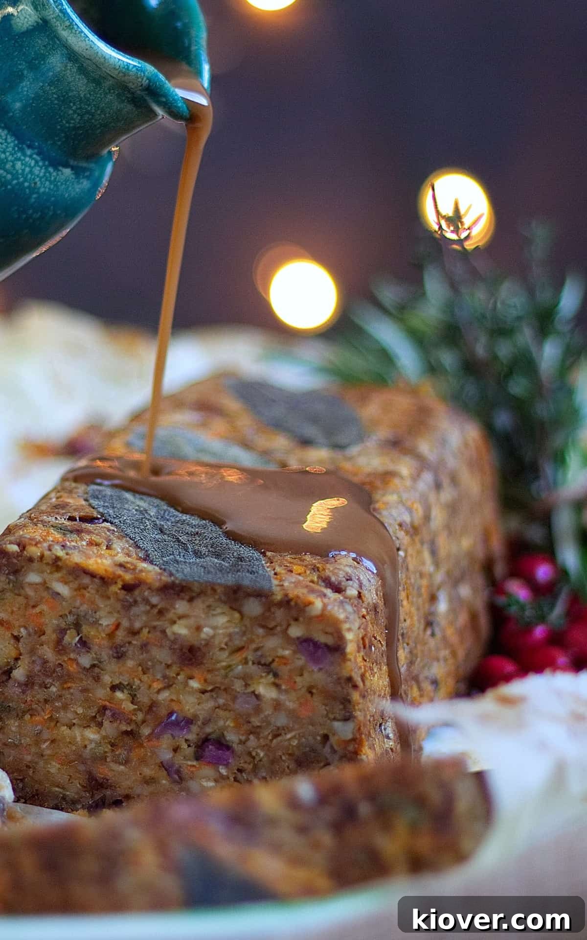 gravy being poured over nut roast. Nut roast is cut open.