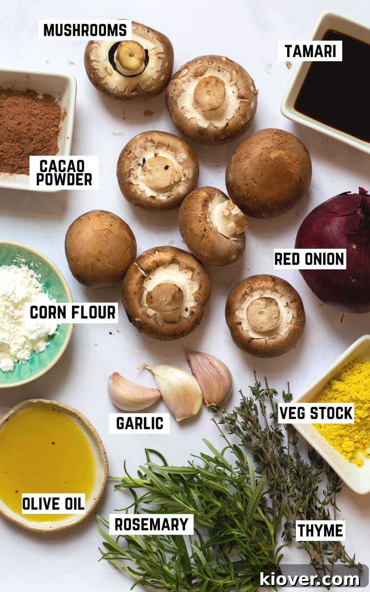 Creamy Mushroom Gravy Recipe for Roast and Mashed Potatoes 3 ingredient flatlay for a vegan gravy: mushrooms, red onion, tamari, corn flour, cacao powder, veg stock, garlic, oil, fresh herbs