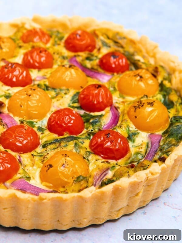 vegan quiche with a crispy pastry served on a marble worktop.