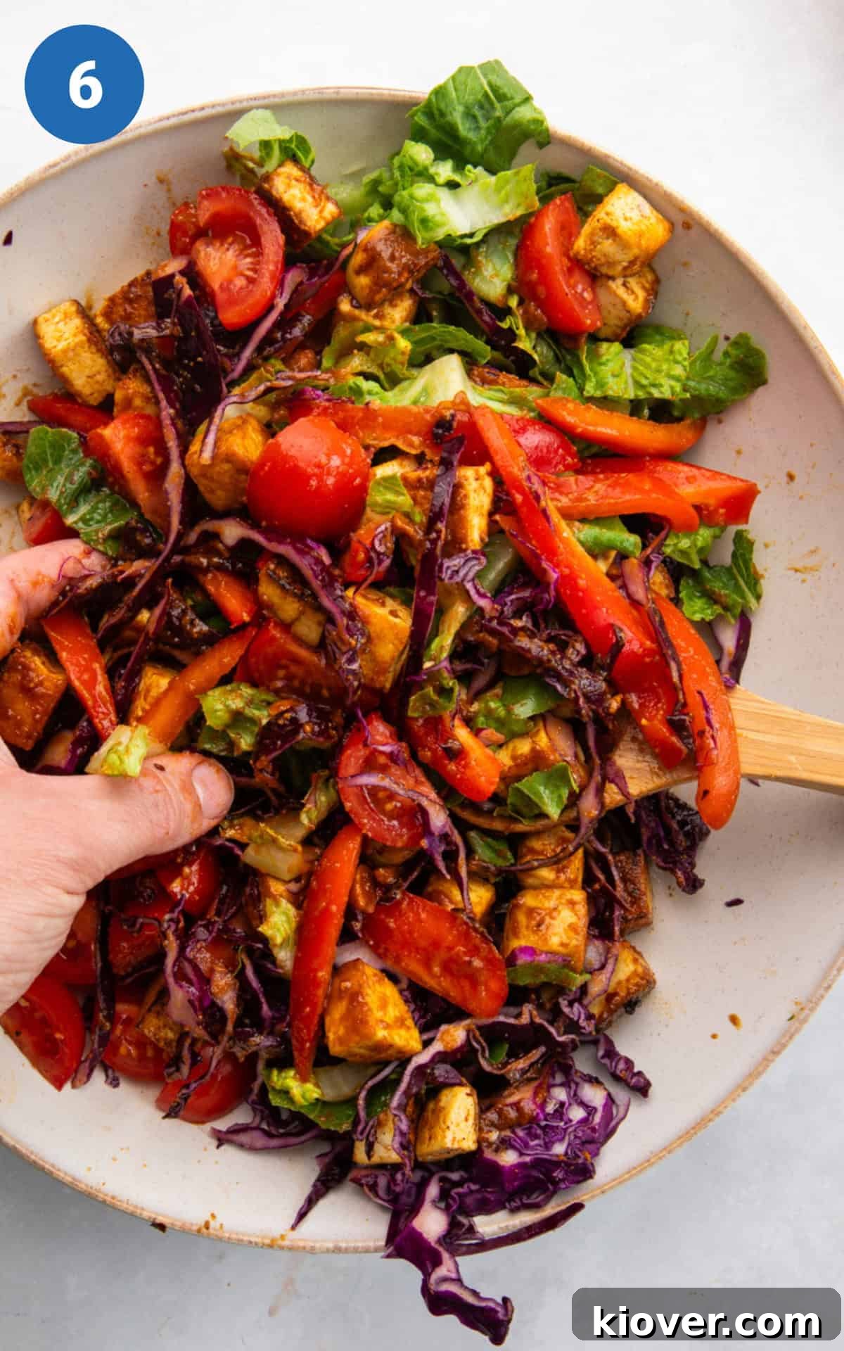 mixing tofu salad with peanut dressing.