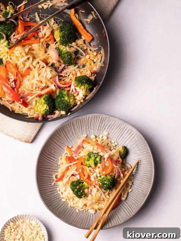 Thai Curry Noodle Soup Recipe — Creamy Thai Coconut Noodle Bowl 10 Vegan Pad Thai served in a plate next to a pan on the table.