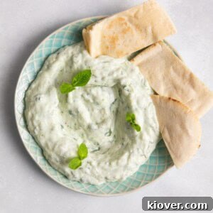 Creamy Vegan Tzatziki Sauce Recipe for Mediterranean Dishes 11 Tzatziki on blue plate accompanied with pittabread
