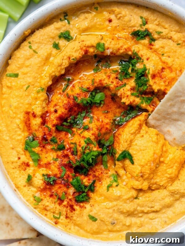 Creamy Vegan Tzatziki Sauce Recipe for Mediterranean Dishes 7 garlic hummus served in a white bowl with pitta and herbs.