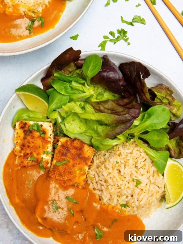Vegan Katsu Curry on a plate with vegetables and rice.