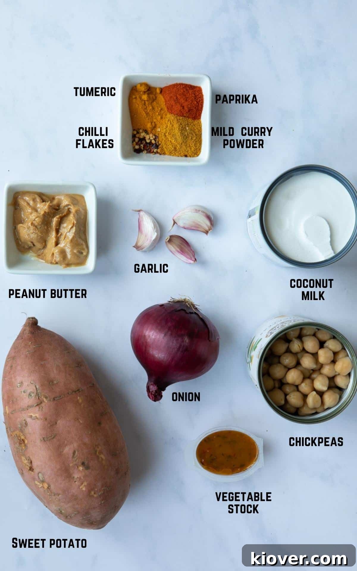 Ingredients to make Sweet Potato Satay Curry laid out on a white marble background.