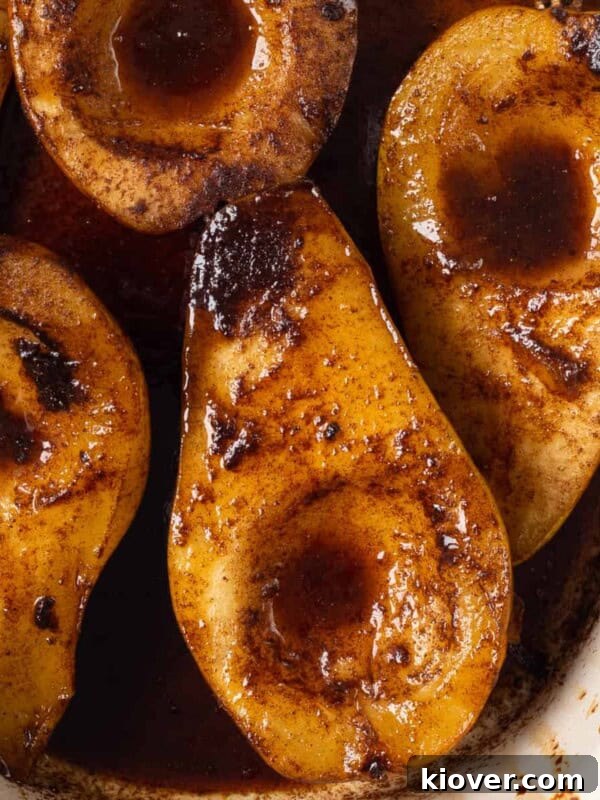 a closeup view of these delicious baked spiced pears coated in a rich sauce.
